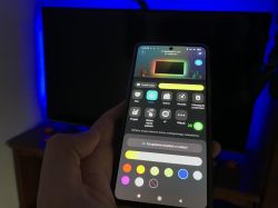 Phone with Govee app in front of a TV backlit in blue