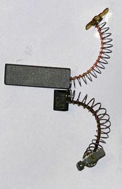 Worn carbon brush with copper wire and spring from a Bosch washing machine