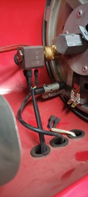 Wnętrze urządzenia grzewczego z widocznymi przewodami i częściami elektronicznymi.