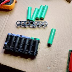 Batteries for Dreame V9 Vacuum on Cardboard Batteries and battery holder on a cardboard surface.