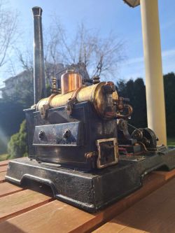 Zrekonstruowany model maszyny parowej Lipsi na stole w ogrodzie.