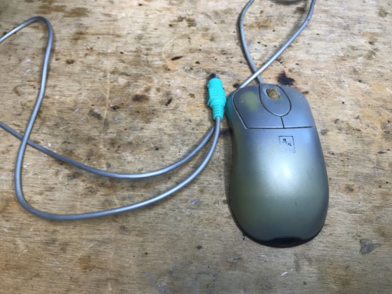Old A4Tech Mouse on Wooden Surface Old A4Tech computer mouse with PS/2 cable on a wooden table.