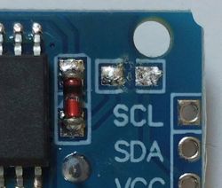 Close-up of a PCB with SCL, SDA and VCC labels, a red diode, and soldered joints visible.