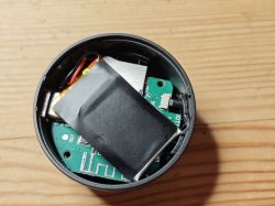Disassembled electronic device with internal components visible Interior of electronic device showing battery and circuit board