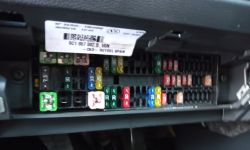 Interior of a fuse box in a car with multicolored fuses.