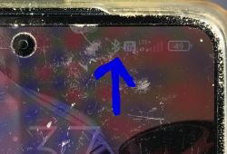 Zbliżenie na ekran smartfona z włączonym Bluetooth i strzałką wskazującą ikonę