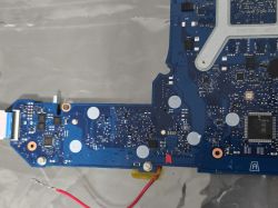 Niebieska płyta PCB z elementami SMD i złączem taśmowym, widok z góry na folii.