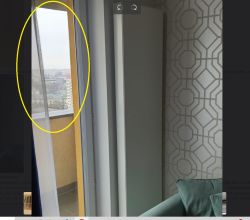 Widok z mieszkania na blokowisko i zabudowę miejską przez otwarte drzwi balkonowe