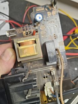 Zbliżenie na płytkę drukowaną z transformatorem i elementami elektronicznymi