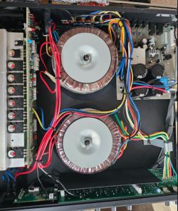 Wnętrze wzmacniacza audio z dwoma dużymi transformatorami toroidalnymi i wiązkami przewodów