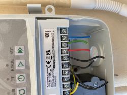Zbliżenie na skrzynkę elektryczną z podłączonymi przewodami w różnych kolorach wewnątrz.