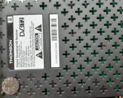 Etykieta dekodera Thomson DVB-T2 o modelu THT808 na perforowanej obudowie.