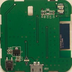 View of a printed circuit board with electronic components, including a button, USB socket, and several SMD components.