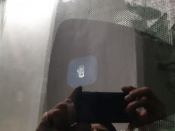 Odbicie dłoni z telefonem w szybie auta z czujnikiem przylegającym punktowo