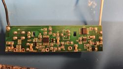 Zdjęcie zielonej płytki drukowanej z różnymi elementami elektronicznymi.