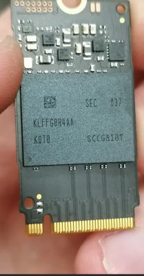Zbliżenie płytki SSD M.2 NVMe z układem pamięci NAND „KLFFG8R4AA” i stykami złącza