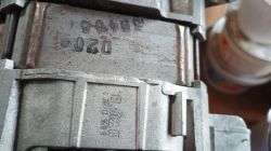 Zbliżenie na metalowy korpus silnika elektrycznego z widocznymi oznaczeniami i numerami seryjnymi.