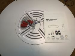 View of slim ceiling light with user manual and mounting kit.