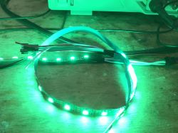 Green LED Strip Connected to Device LED strip with green-lit LEDs connected to a device.