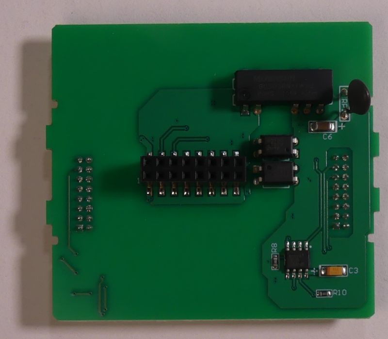 Zielona płytka drukowana PCB z kilkoma zamontowanymi podzespołami elektronicznymi i złączem czarnym pośrodku.