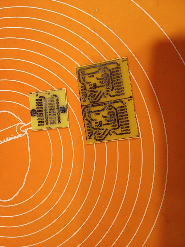 Two printed circuit boards on an orange background with white circles.