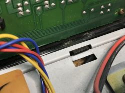 Zbliżenie na wnętrze starego tunera satelitarnego z widoczną płytą PCB i kolorowymi przewodami.