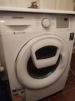 Pralka Samsung Eco Bubble z dodatkowymi drzwiczkami AdWash, częściowo zdemontowana.