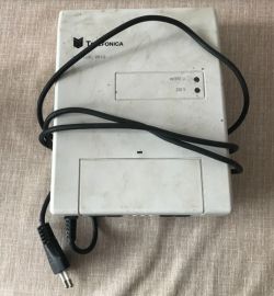 Białe urządzenie Telefonica z przewodem zasilającym i panelem diodowym