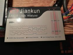 Analizator logiczny Jiankun LA5016 na stole z przewodami.