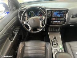 Interior of a Mitsubishi car showing the steering wheel, dashboard panel, and center console.