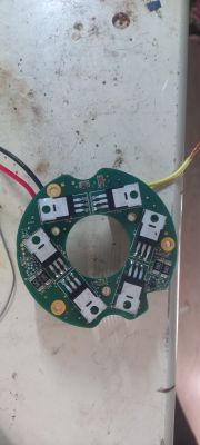 Płytka drukowana z elementami elektronicznymi leży na powierzchni stołu.