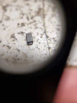 Mała dioda prostownicza SMD z oznaczeniem 8P2 514 na tle nierównej powierzchni.