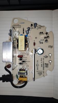 Płytka drukowana z elementami elektronicznymi i czarnym przewodem na kartce w linie