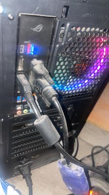 Tylny panel komputera z podłączonymi kablami HDMI i DVI, widoczne złącza USB i porty audio.