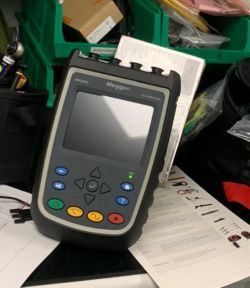 Przyrząd pomiarowy Megger MPQ1000 stojący na stole z dokumentacją techniczną wokół