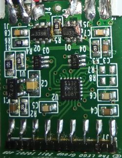 Zbliżenie na zieloną płytkę drukowaną z komponentami elektronicznymi.