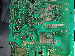 Zbliżenie na zieloną płytkę drukowaną z komponentami elektronicznymi.