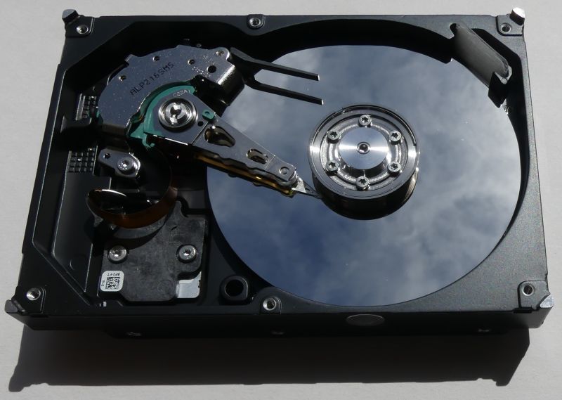 Interior of an open hard drive showing the platter and read/write arm.