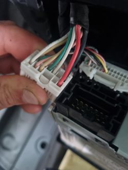 Złącze kabli samochodowych z widocznymi kolorowymi przewodami.