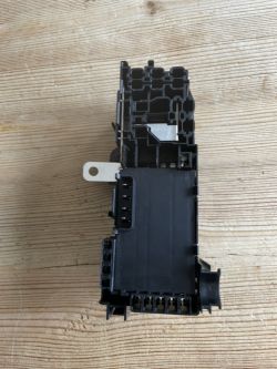 Photo of a new fuse box from VAG on a wooden surface.