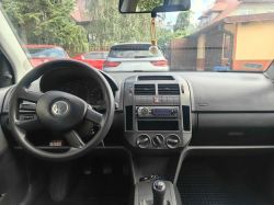 Interior of a Volkswagen car, view from the driver's side, showing the steering wheel, center console, and gear stick.