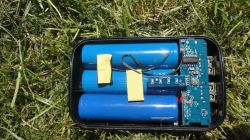 Otwarty powerbank z trzema niebieskimi ogniwami 18650 i widoczną płytką drukowaną