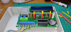 Dual-channel timer with an LCD display, relays, and a battery on a circuit board.