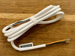 White cable with exposed wires at one end, lying on a wooden background.