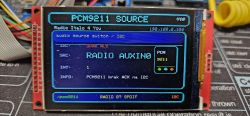 TFT screen showing “PCM9211 SOURCE” UI with “RADIO AUXIN0” message, surrounded by wires
