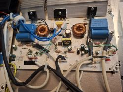 Wnętrze modułu płyty indukcyjnej: płytka PCB z radiatorami, cewkami i niebieskimi przekaźnikami