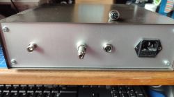 Panel tylny metalowej obudowy urządzenia elektronicznego z czterema różnymi złączami i gniazdem zasilania.