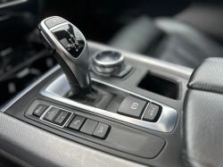 Car gear shift lever with control panel and knob.