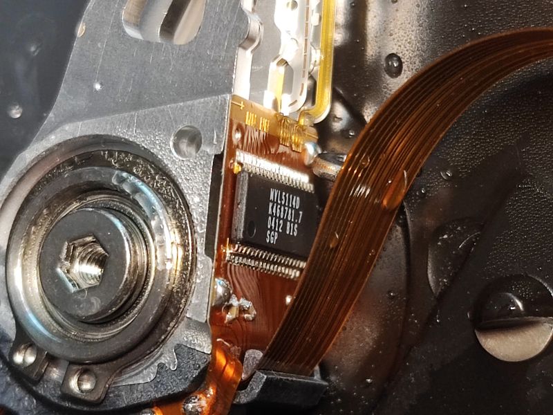 Interior of Hard Drive with Visible Moisture Close-up of a hard drive interior showing the actuator coil and moisture.