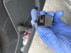 Osoba w rękawiczkach trzyma przekaźnik w ręku.